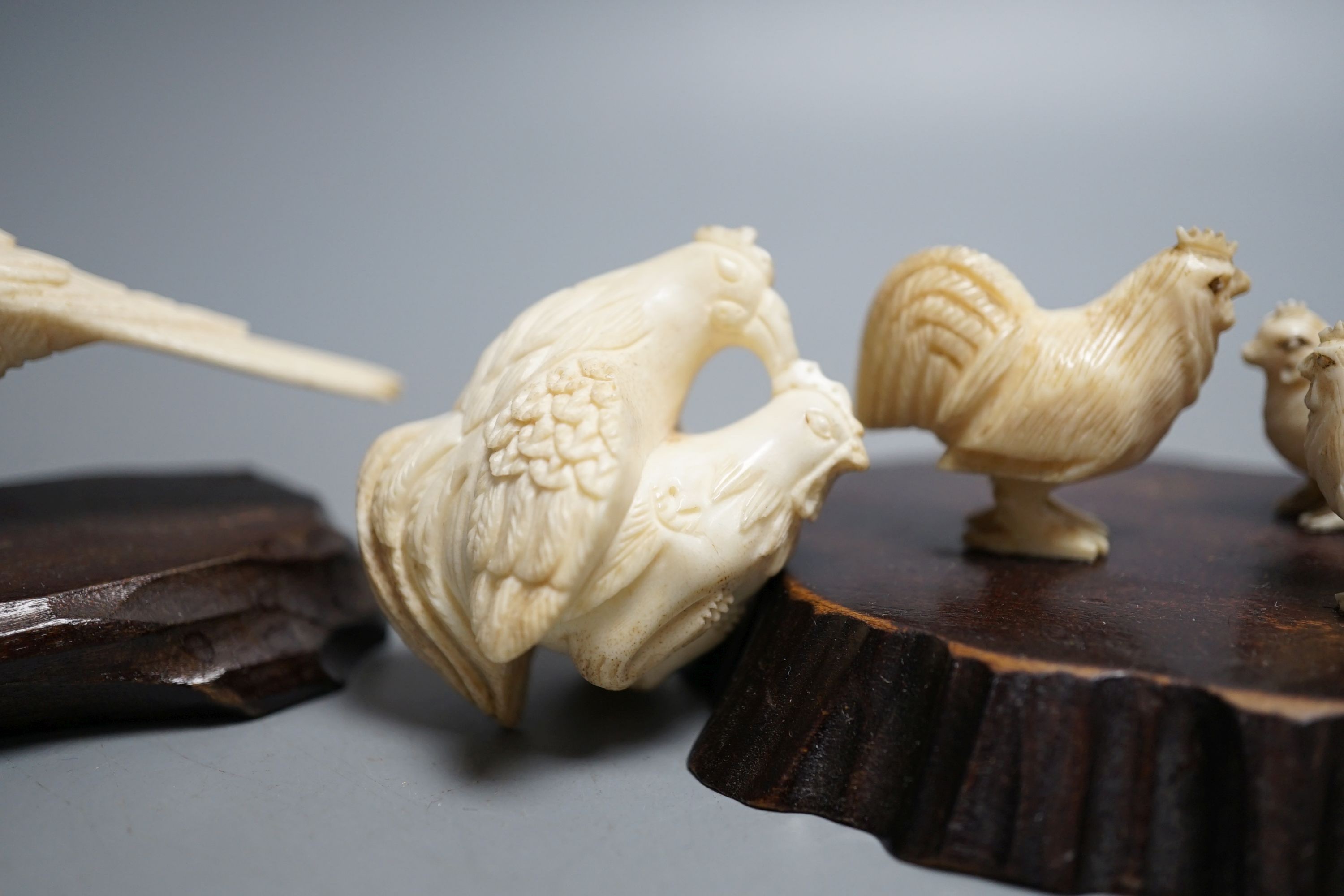 A Japanese Meiji period ivory bird with mother of pearl eyes, a Japanese group of three chickens and Japanese copulating chickens